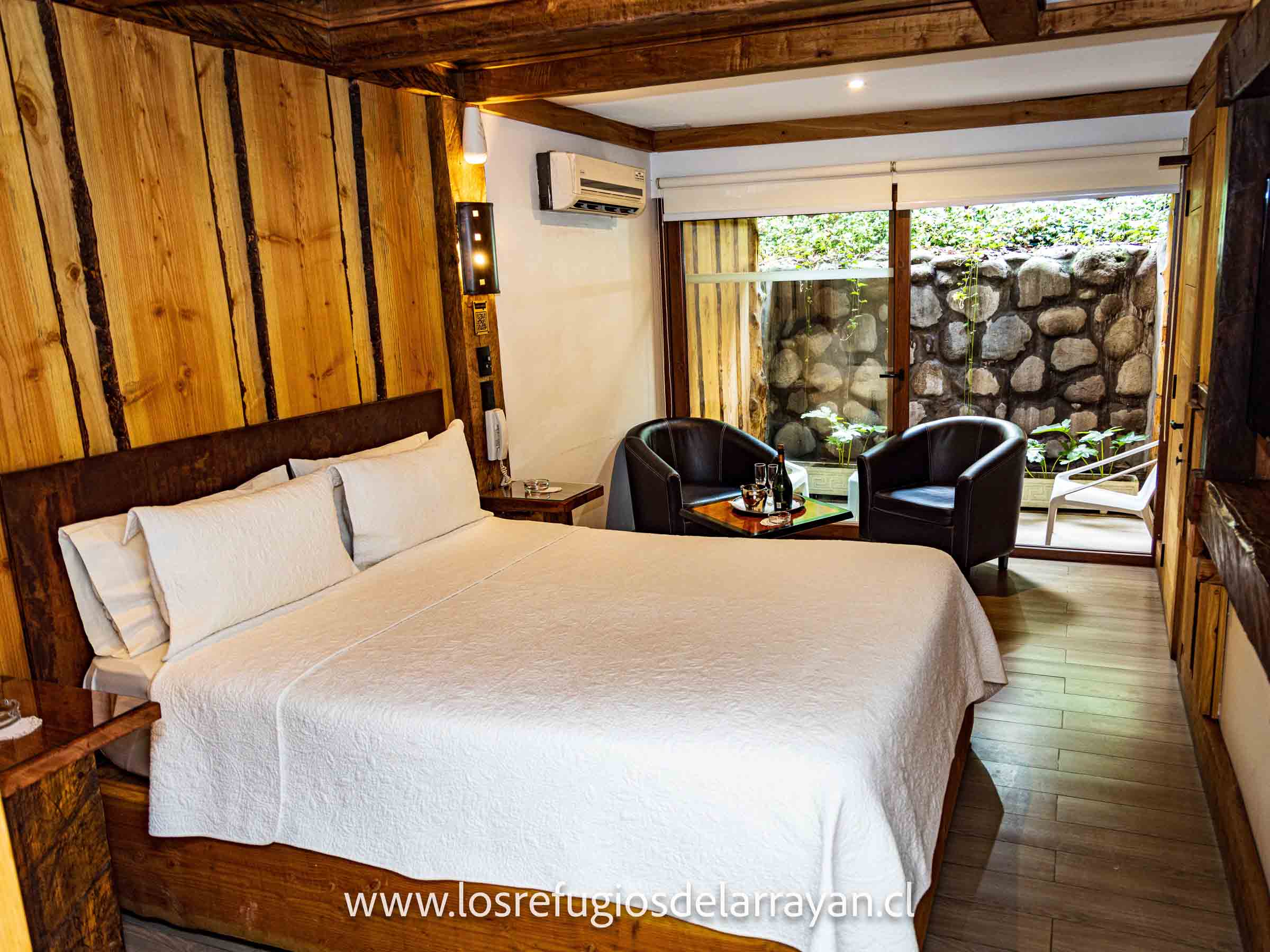 Habitación cabaña con sillones y ventanal a la terraza